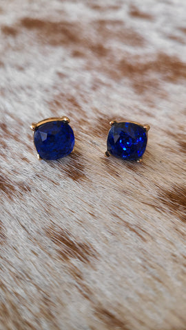 Round glitter studs set in gold in royal blue